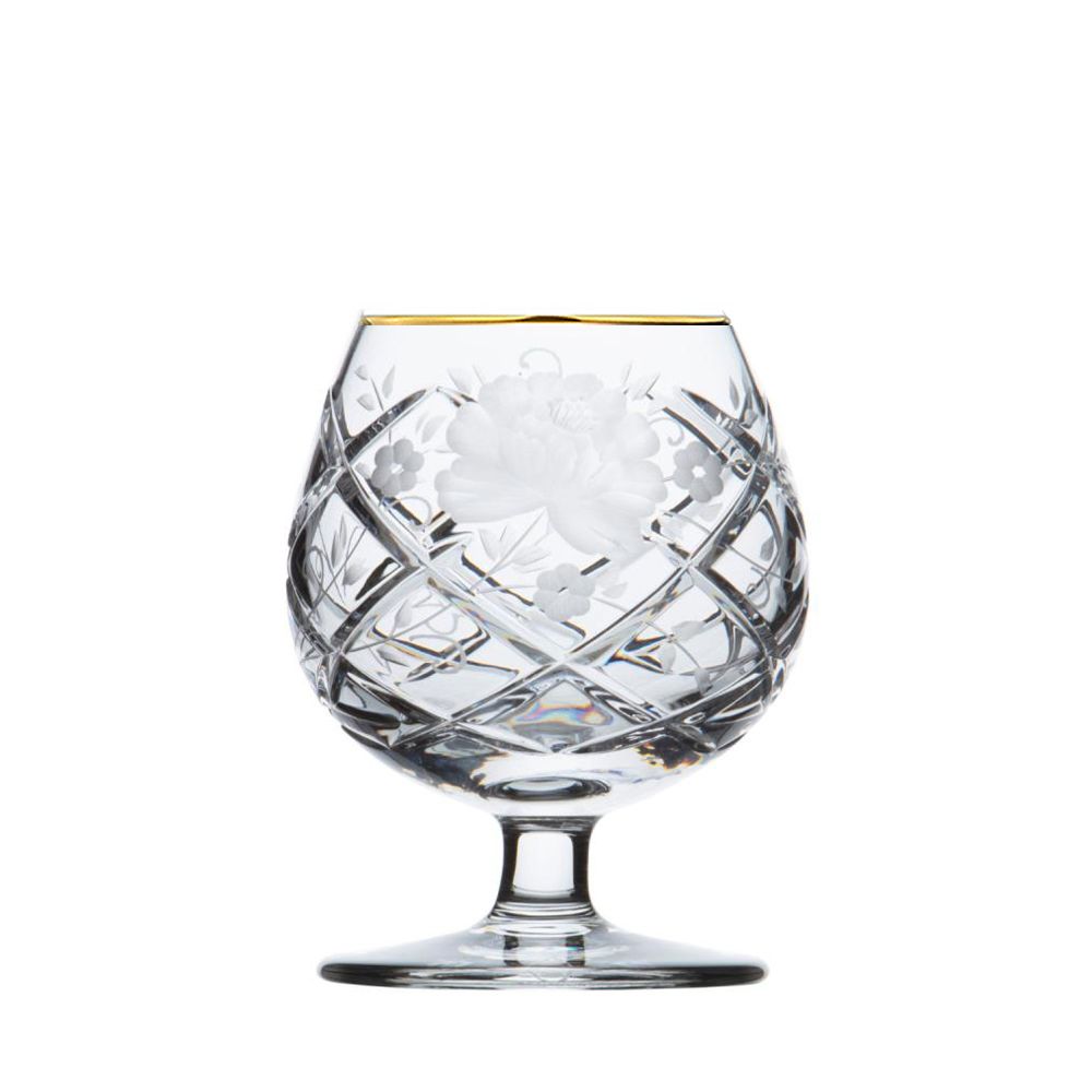 Elegantes, klar geschliffenes Kristall-Cognacglas auf weißem Hintergrund. Bauchige Form mit diagonalem Rautenmuster. Mittig große mattierte Blüte, umgeben von kleineren Blumen und Blättern. Rand mit feinem Goldband.